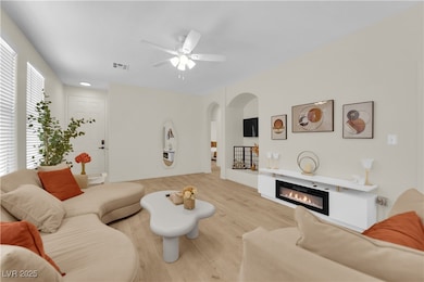 Living area with arched walkways, a ceiling fan, l