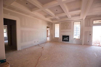 Unfurnished living room with a fireplace, beamed ceiling, and coffered ceiling