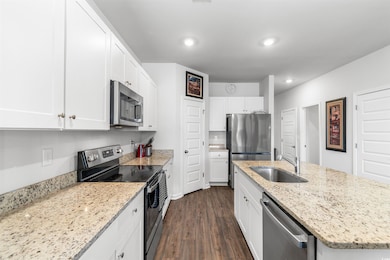 Kitchen with dark wood-type flooring, sink, light 