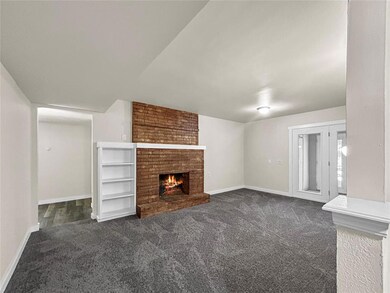 Unfurnished living room featuring brick wall, dark