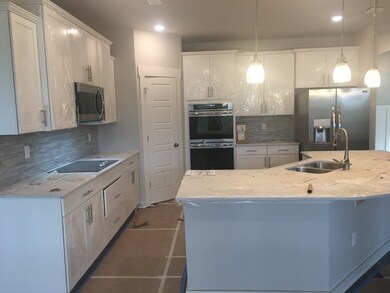 Kitchen is huge with all stainless steel appliances, quartz countertops, hardwood flooring and double ovens included