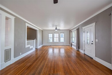 Unfurnished room featuring ornamental molding, ceiling fan, and dark hardwood / wood-style flooring