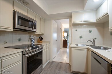 Kitchen featuring backsplash, cream cabinets, sink