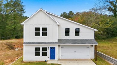 View of front of property featuring a shingled roof, board and batten siding, driveway, a garage, and a front yard