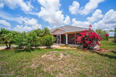 Back of house with a yard, stucco siding, and a su