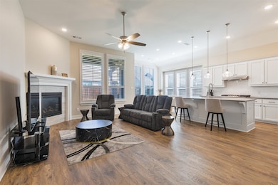 Living room featuring dark wood-style floors, a fireplace, recessed lighting, and ceiling fan
