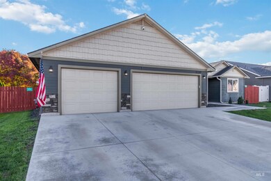 Ranch-style house featuring a garage, stone siding, and an outbuilding