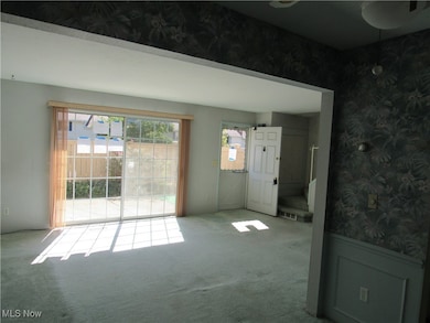 Spare room featuring wallpapered walls and carpet floors