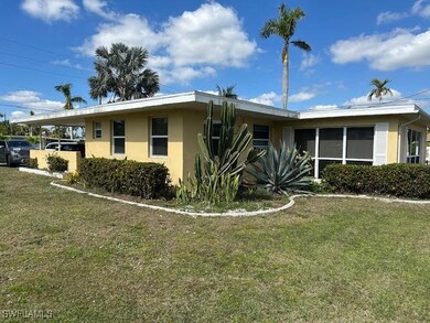 Single story home featuring a front lawn and a car