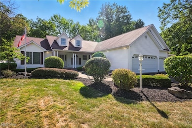 Cape cod-style house featuring a porch, a front lawn, and a garage