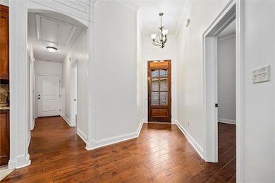 Entryway with dark wood-style floors, a chandelier