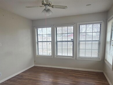 Spare room featuring baseboards, dark wood-style f