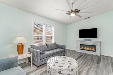 Living area featuring a textured ceiling, light wo