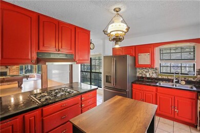 Opposite view. Gas stove & kitchen island.