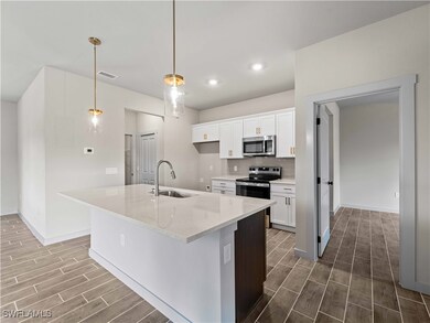 Kitchen with stainless steel appliances, hanging l