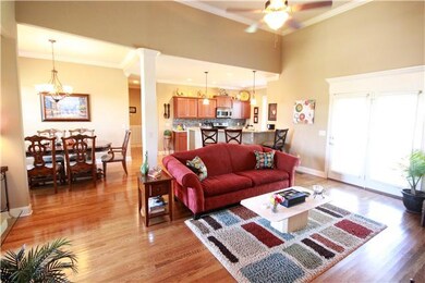 Bright, open living area features gleaming finished in place hardwood floors.