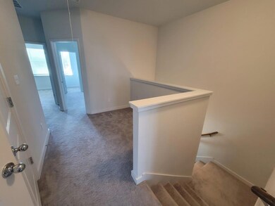 Hallway with carpet floors, baseboards, and an up