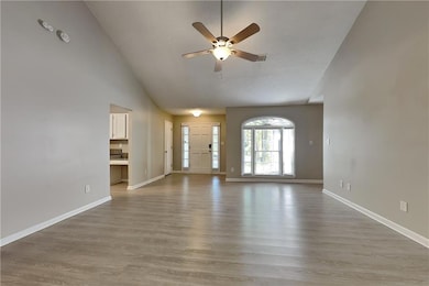 Unfurnished living room featuring ceiling fan, lig