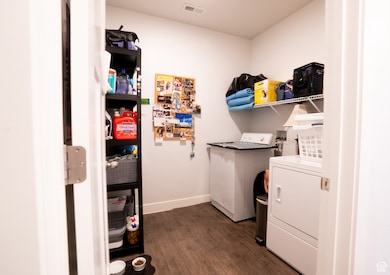 Laundry room featuring dark wood-type flooring and independent washer and dryer