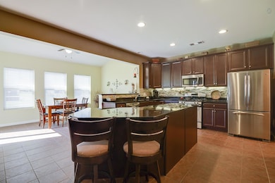 Stainless appliances, gas stove, granite countertops, gorgeous tile backsplash, and tile floors.