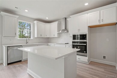 Kitchen with white cabinetry, light hardwood / woo