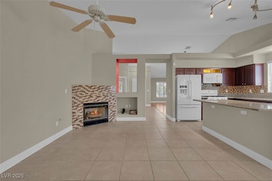 Kitchen with white appliances, light tile patterne