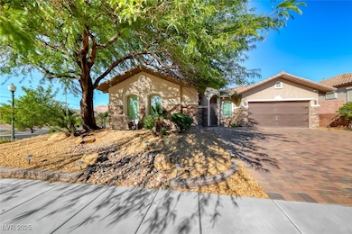 Mediterranean / spanish-style home with stone siding, stucco siding, decorative driveway, and a garage