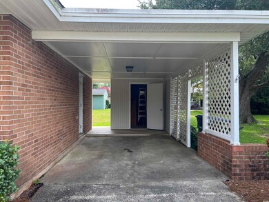 View of parking / parking lot featuring a carport
