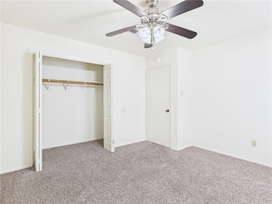 Unfurnished bedroom featuring carpet, a closet, and a ceiling fan