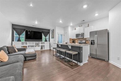 Living room featuring dark wood-type flooring, recessed lighting, and baseboards
