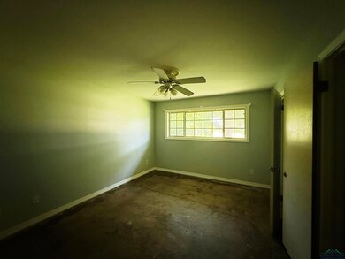 Spare room featuring concrete floors and ceiling fan