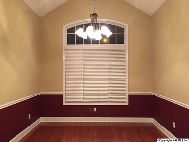 To the right of the foyer is the dining room with it's cathedral ceiling and hardwood flooring.
