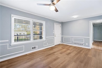 Spare room featuring crown molding, ceiling fan, a