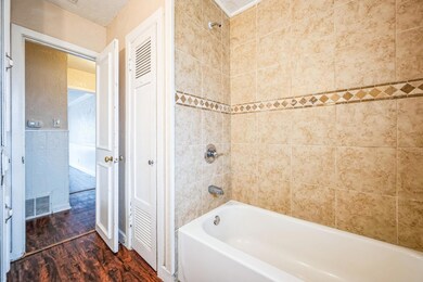 Bathroom featuring a textured ceiling, tiled showe