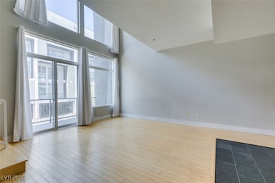 Unfurnished living room with baseboards, a towerin