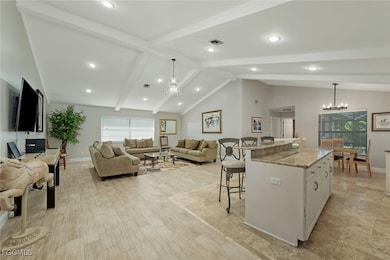 Kitchen featuring a chandelier, a breakfast bar, l