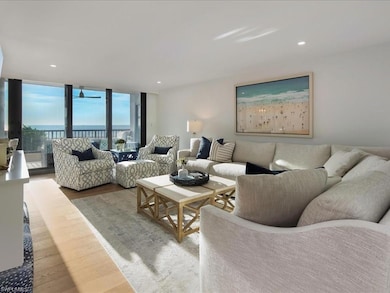 Living room with wood finished floors, recessed lighting, a water view, and floor to ceiling windows