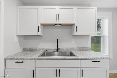 Kitchen featuring light countertops and white cabinetry