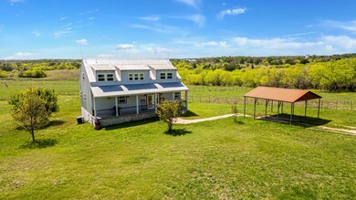 Back of house featuring covered porch, a rural vi