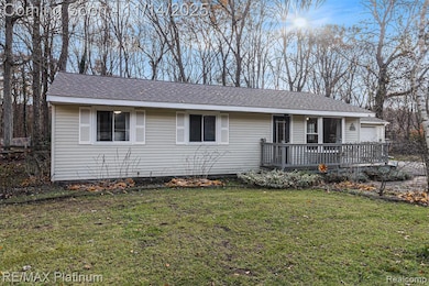 Ranch-style home featuring a front yard, a shingled roof, and a garage