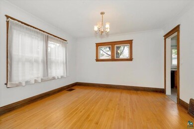 Empty room with an inviting chandelier, light wood