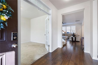 Corridor with stairway, dark wood finished floors, and dark colored carpet