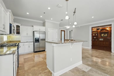 Elegant kitchen featuring granite countertops, stainless steel appliances, and a spacious island with pendant lighting.