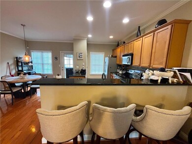 Kitchen featuring black microwave, stainless steel electric range, a peninsula, ornamental molding, and freestanding refrigerator