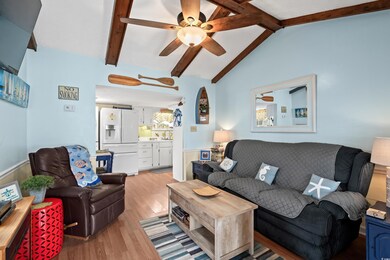 Living room featuring lofted ceiling with beams, l