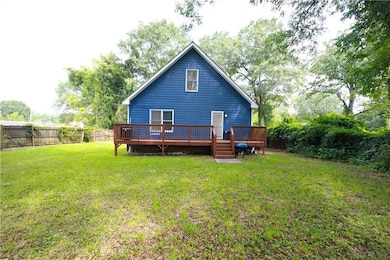 Rear view of property featuring a fenced backyard and a wooden deck