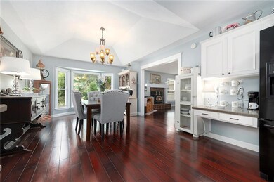 Dining area featuring a chandelier, dark wood finished floors, and vaulted ceiling