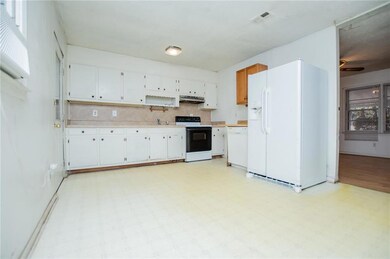Kitchen featuring white appliances, light countertops, light floors, tasteful backsplash, and under cabinet range hood