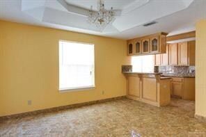 Kitchen with a notable chandelier, plenty of natural light, a raised ceiling, and visible vents