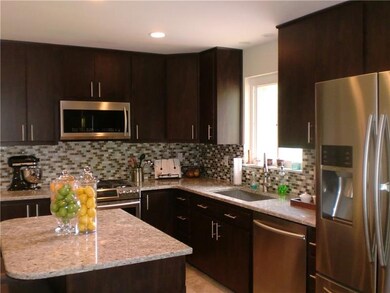The Kitchen's dark cabinets are complimented by the lighter granite countertops, backsplash, stainless appliances and recessed lighting!
